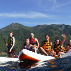 Image shows a group of people sitting on stand-up paddleboards