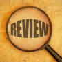 Image of the word review under a magnifying glass.