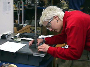 Here a student is in the layout stage. She is marking the material for drilling and taping.