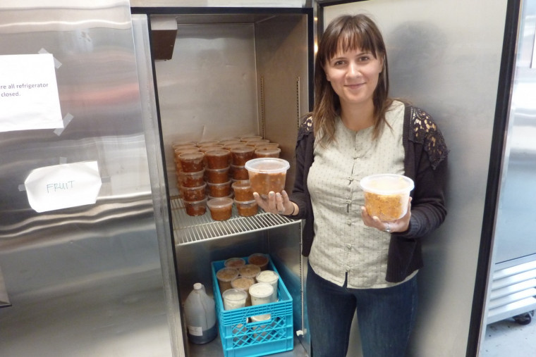 Ava Mikolavich, Program Coordinator for Urban Gleaners, stores jars of soup donated by Lewis & Clark