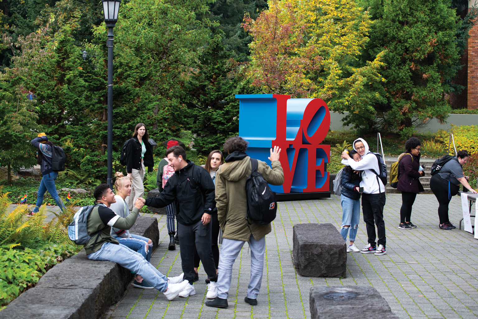 Students mingle outside J.R. Howard Hall, where Robert Indiana's iconic LOVE sculpture is on display through the fall.