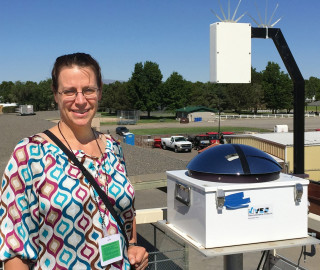 Assistant Professor Jessica Kleiss with a TSI, which captures images of the sky every 30 seconds.