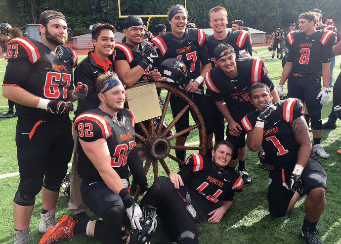 After beating Willamette, several seniors pose with the Wagon Wheel traveling trophy. (lcpioneers.com)