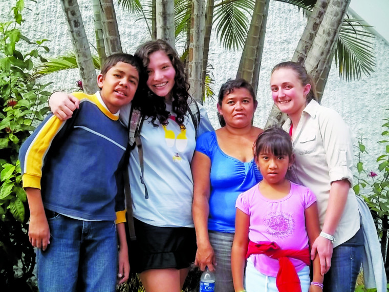 Lucy Roberts CAS '14 and Mia McLaughlin CAS '14 with their host family in El Salvador.