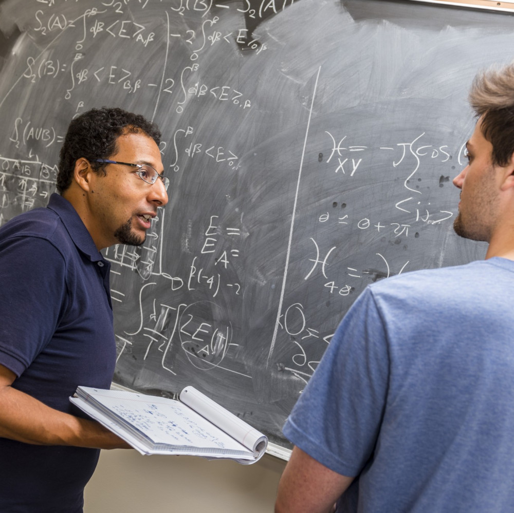 Physics professor Mohamed Anber and physics major Ben Kolligs '18 work through a theoretical ...