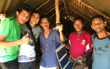 Ary Hashim BA '20 and members of the project team with equipment from the first solar installatio...