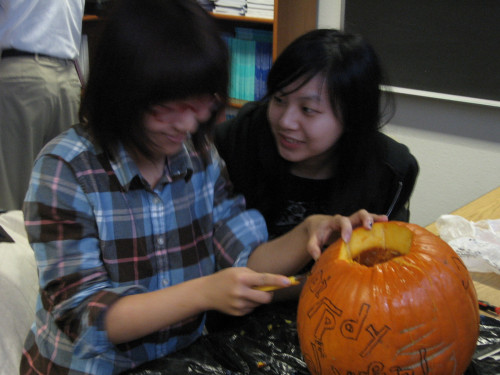 Two girls working together on pumpkin