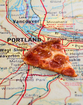 Slice of pepperoni pizza over a map of Portland.