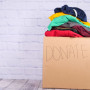 A picture of a box labeled: Donate and clothing items that are neatly folded inside the box.