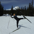 Gillian, a skate ski instructor puts her leg in the air while on a skate ski clinic posing and sm...