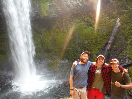Image shows: Three people standing in front of a waterfall.