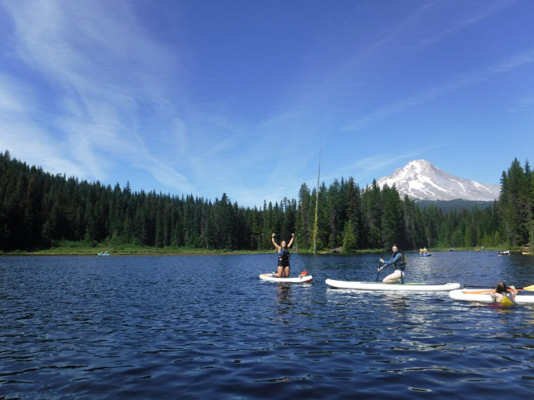 Student Stand Up Paddleboard on a lake with a view of Mt. Hood