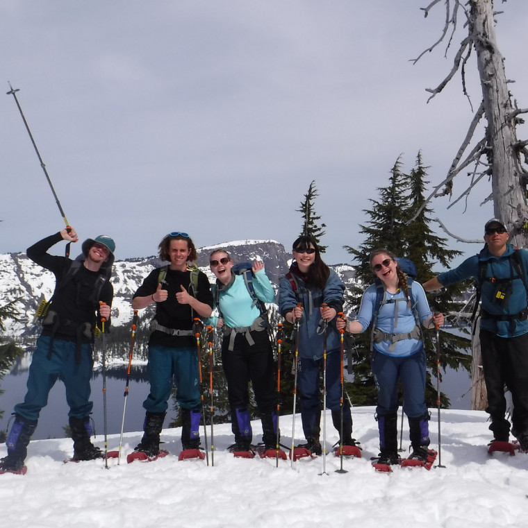 Participants pose in front of Crater Lake in the snow.