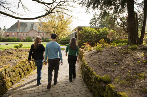 Students arrive on the Graduate Campus via a tree-lined path. The forest on either side is filled...