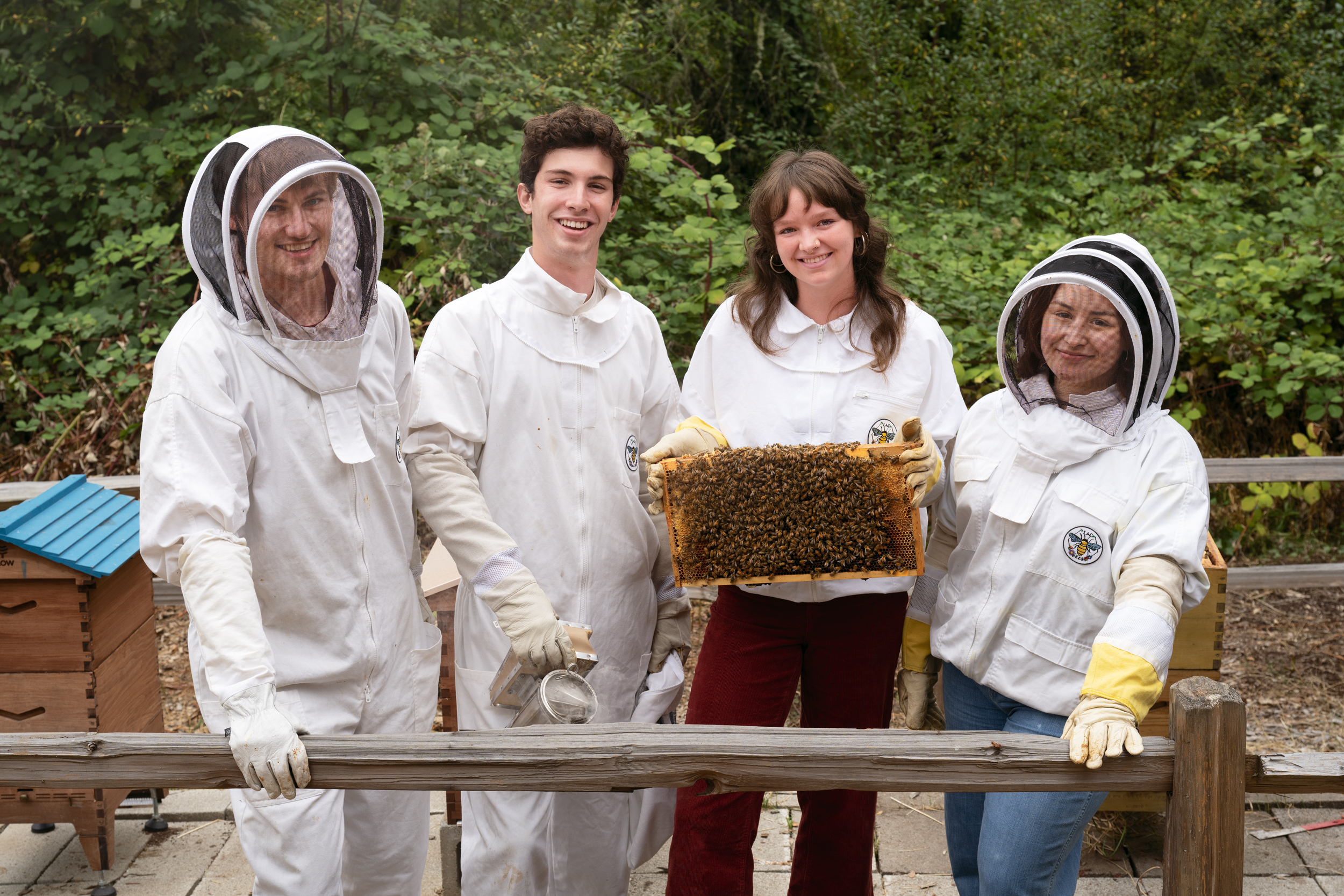 Four students in beekeeping clothes.