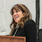 Monica Lewinsky smiles to an audience at lectern