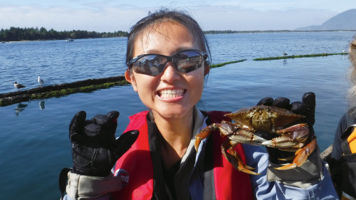 A student from Professor Nilsen's trip shows off her prize catch of a Dungeness crab. (College Outdoors)