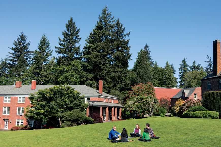 Students sitting in a circle on the lawn at the graduate school.