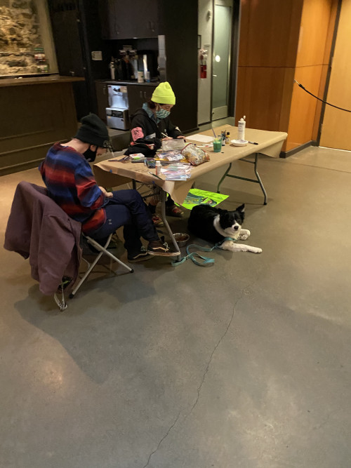 Two supporters paint while their dog lies under the table at the BLM Art Event at The Armory in P...