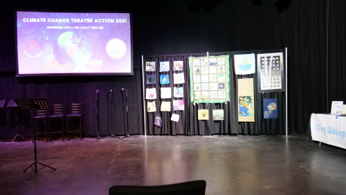 Art for Social Change quilt squares and quilts by the Westside Quilters Guild set up in the theatre.