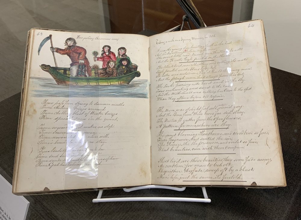 An open book with an illustration of people in a boat followed by text.