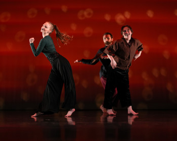 Students dancing against a red background.