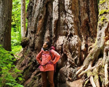 Mila Pruiett ?22岁，站在一棵巨大的树前，这是她的研究对象。