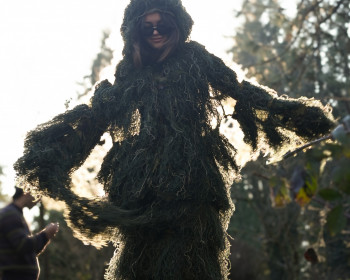 A student wearing a full-body moss suit.