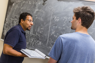 Physics professor Mohamed Anber and physics major Ben Kolligs BA '18 work through a theoretic...