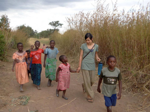 Megumi Nagata '11 walking in Mangulu Village, Malawi. She is holding hands with her host sister, Promise.