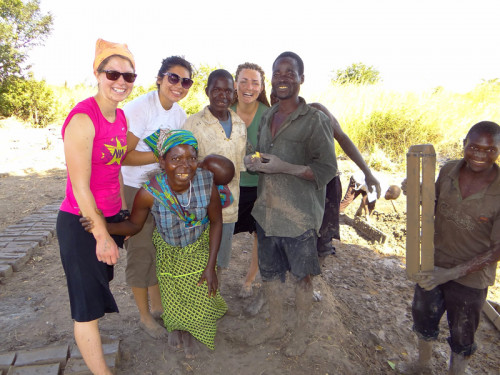 Katie Keith '15, Katherine Quaid '14, and Maddy Kidd '14 pose with villagers during a break from making bricks.