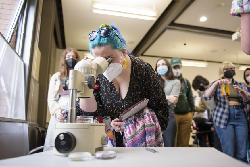 Student using a microscope during Festival of Scholars and Artists 2022.
